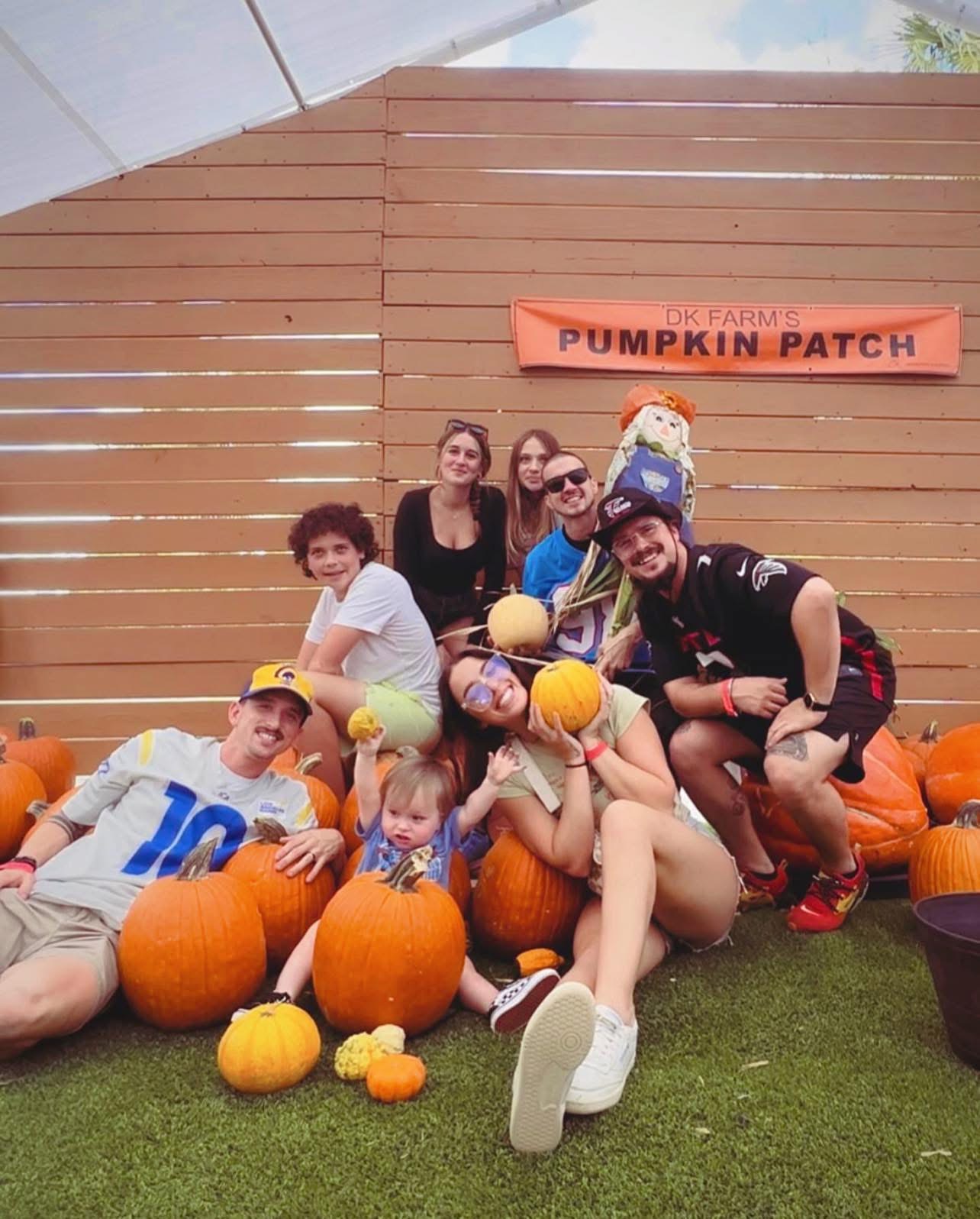 The family at a pumpkin patch in the fall